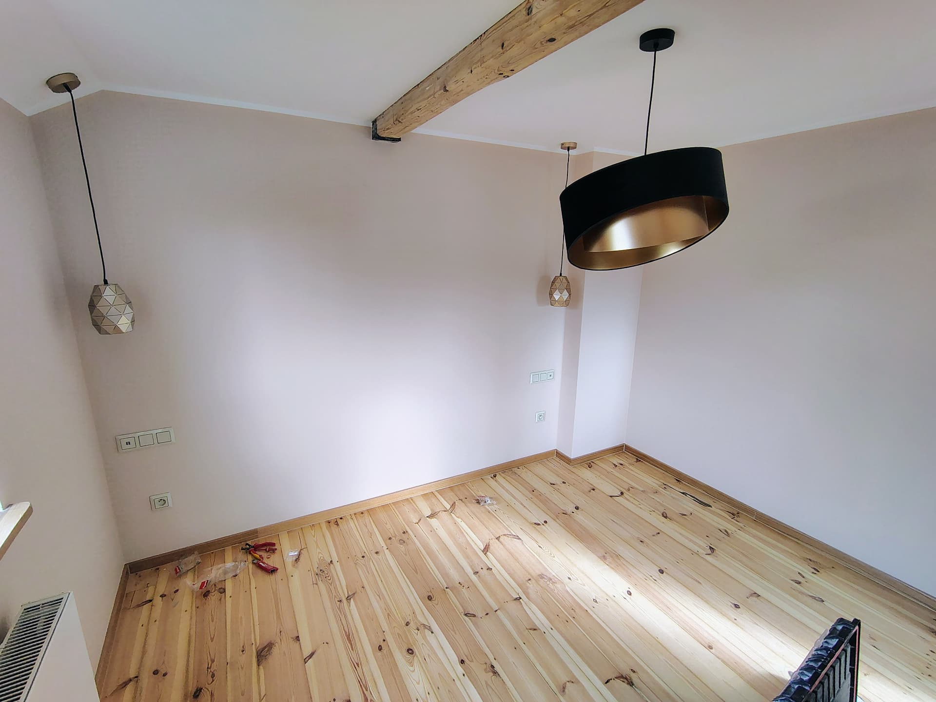 Nowoczesne lampy wiszące i belka sufitowa w salonie