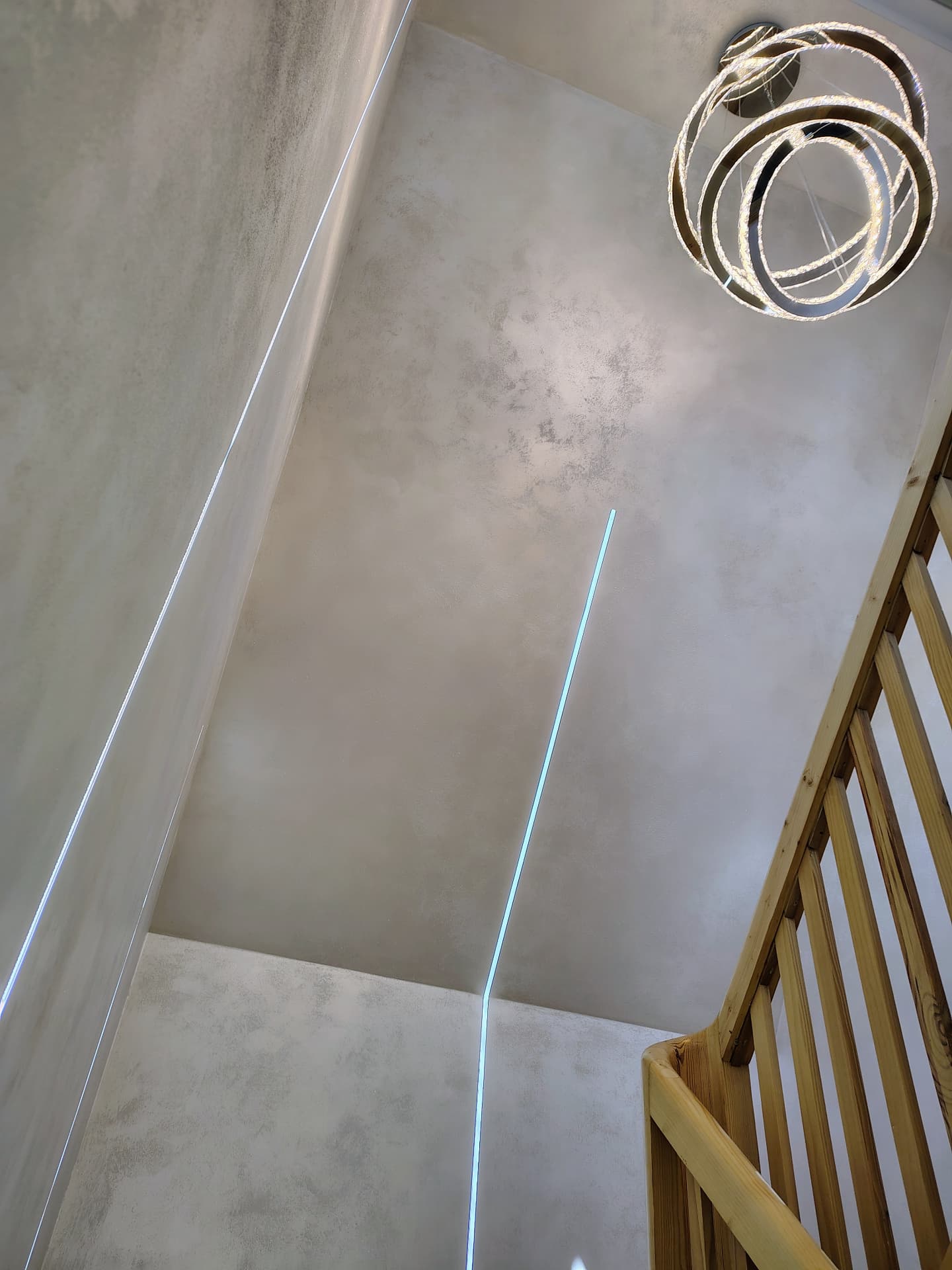 Sufit z podświetlanymi liniami LED oraz designerską lampą