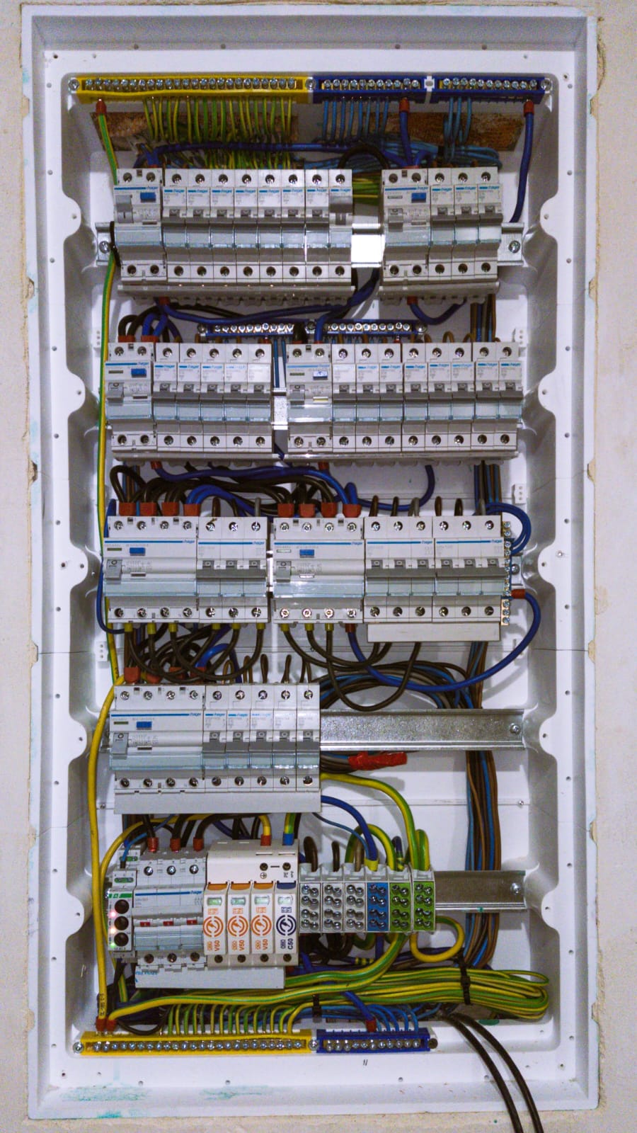 Duża rozdzielnica elektryczna z wieloma wyłącznikami i kolorowym okablowaniem