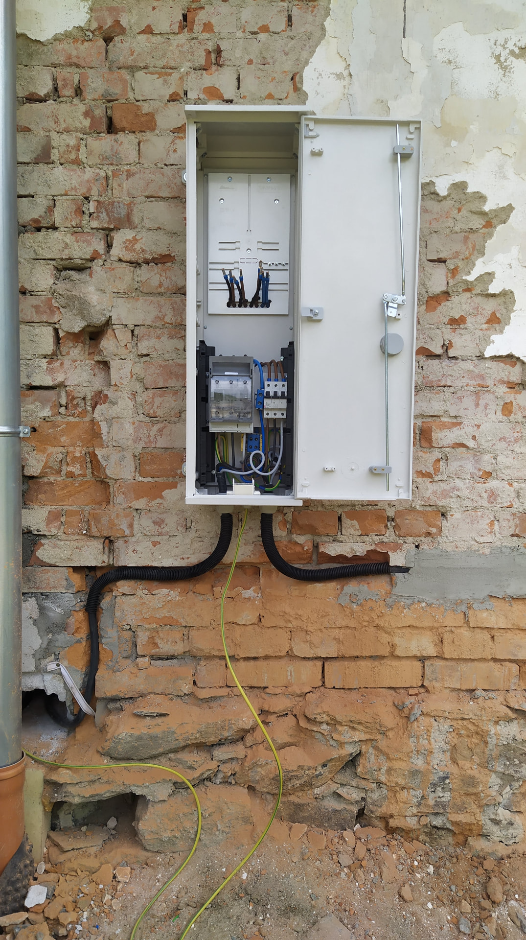 Zewnętrzna skrzynka elektryczna na starej ceglanej ścianie